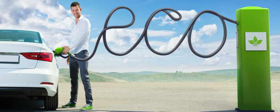 Man charging an electric car and the charging cable spells out the word eco