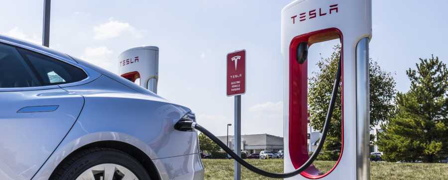 White Tesla charging at Tesla charging stations