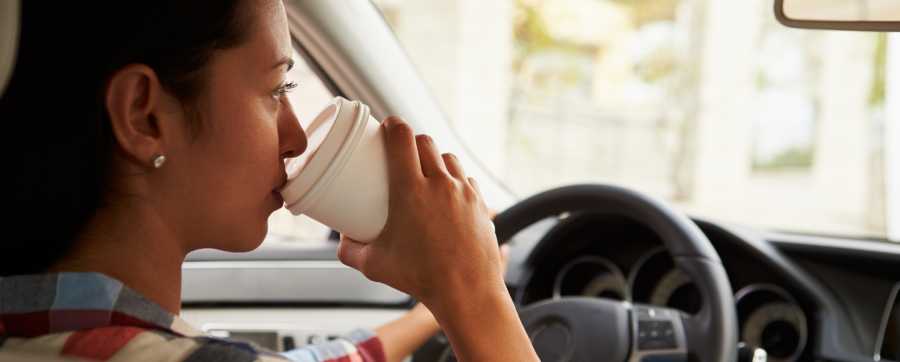 Woman sipping coffee in a car