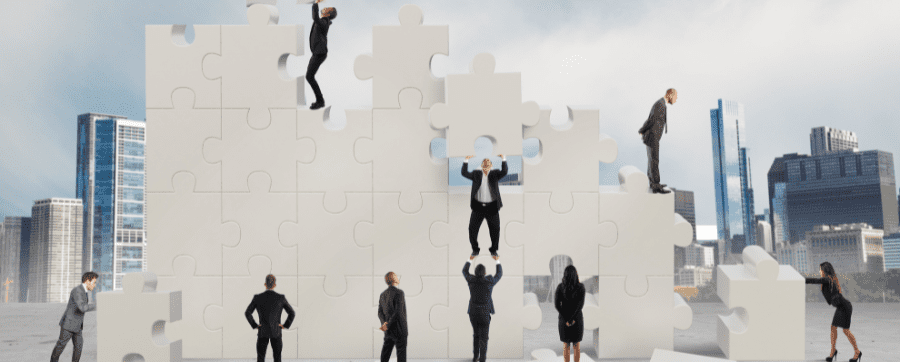 Workers and business people working together holding puzzle pieces