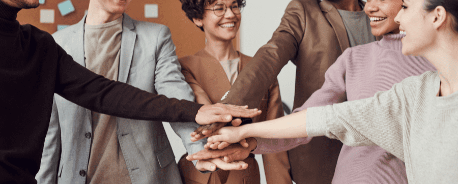 Workers holding their hands into a circle formation